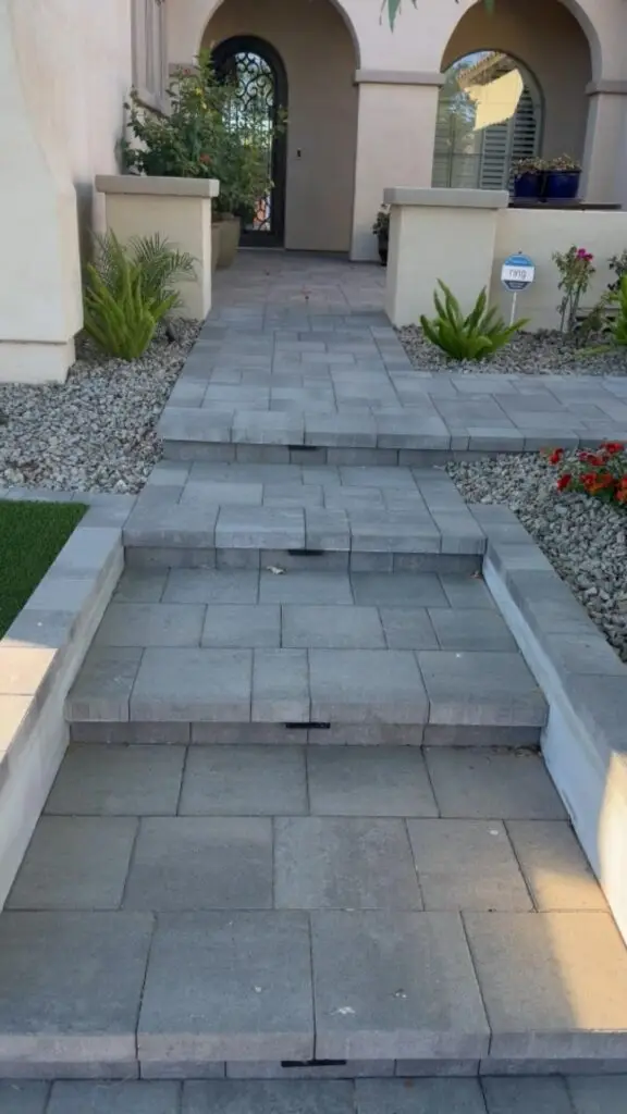 Paved steps leading to a modern entryway, surrounded by decorative plants and gravel landscaping, enhancing the outdoor aesthetic of a residential property in Gilbert, AZ.