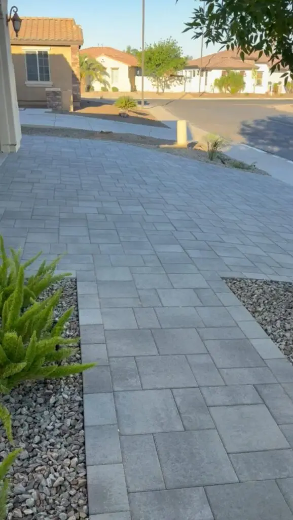 Modern paver walkway leading to a residential home, surrounded by low-maintenance landscaping, showcasing a contemporary outdoor design in Gilbert, AZ.