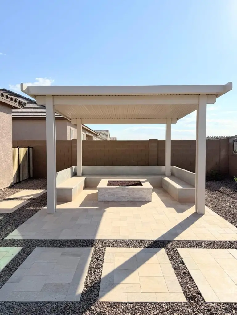 Backyard retreat featuring a modern pergola, travertine flooring, and fire pit, designed for family relaxation in Queen Creek, AZ.
