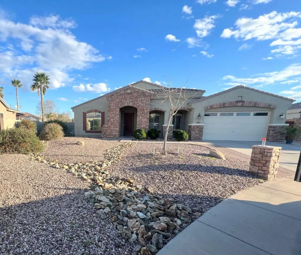 Front yard remodel in Chandler, AZ featuring modern stone accents, decorative gravel, and low-maintenance landscaping with a welcoming entrance.