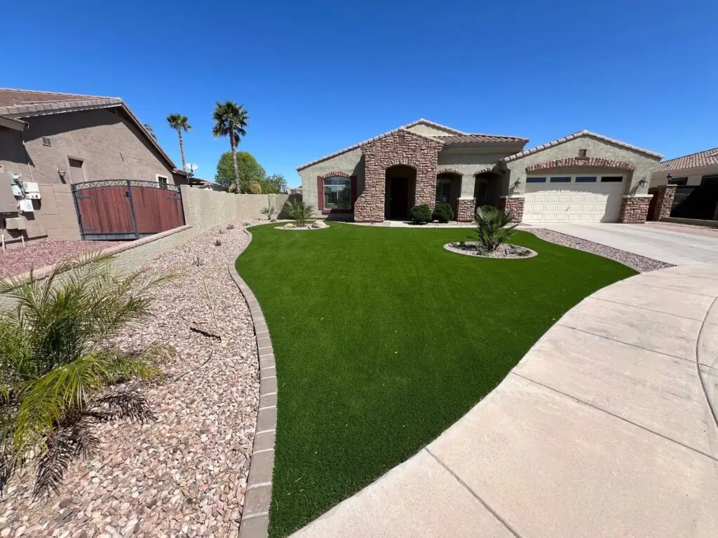 Front yard remodel in Chandler, AZ featuring vibrant artificial turf, modern concrete pavers, and strategically placed plants, enhancing curb appeal and creating an inviting outdoor space.
