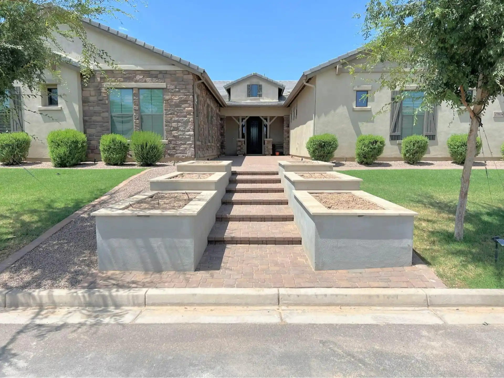 Front yard remodel featuring stone accents, landscaped pathways, and planter boxes, enhancing the outdoor space for a residential property in Queen Creek, AZ.