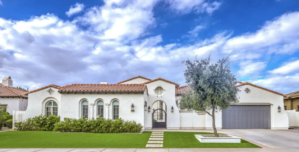 Front yard of a Spanish style Chandler, AZ home with artificial turf, low desert plantings and a paver walkway to the entry